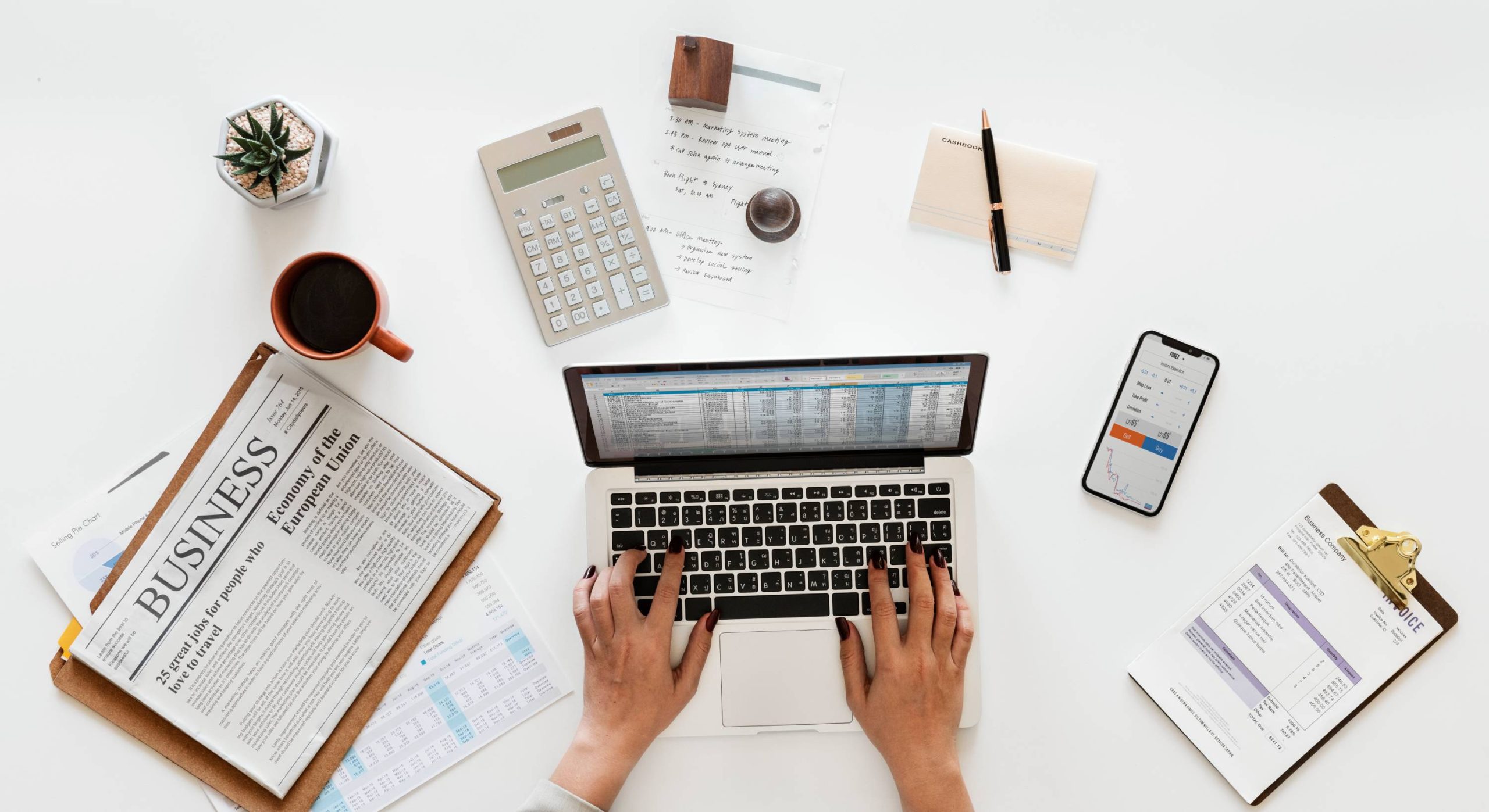 Overhead view of a business owner working on accounting software on a laptop